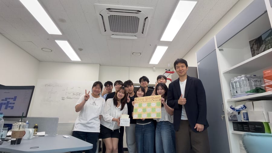 ML3 members celebrating Teacher's Day in the lab with a handmade message board.